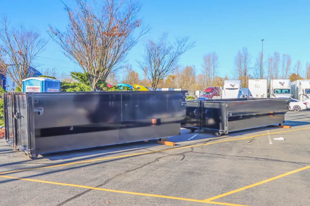 Professional dumpster rental service with roll-off container on residential driveway in Bigfork